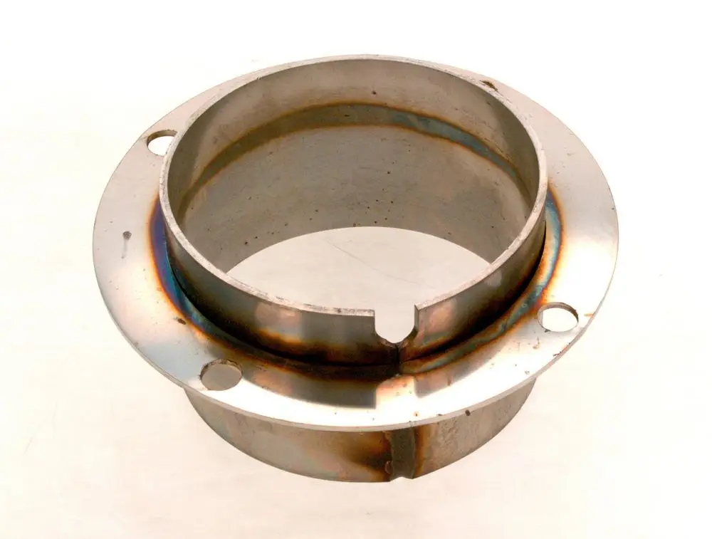 Metallisches Bauteil mit flacher Basis und kreisförmiger Öffnung, umgeben von Befestigungslöchern, möglicherweise Teil eines Bosch Brenners.